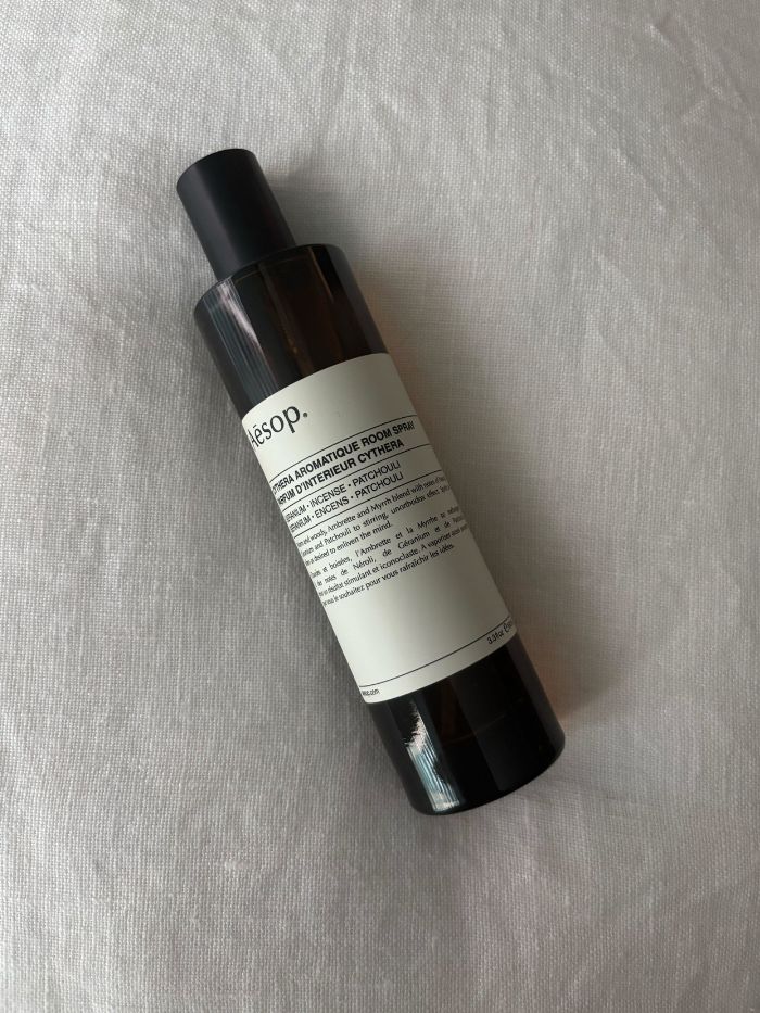 An Aesop room spray on a white linen background