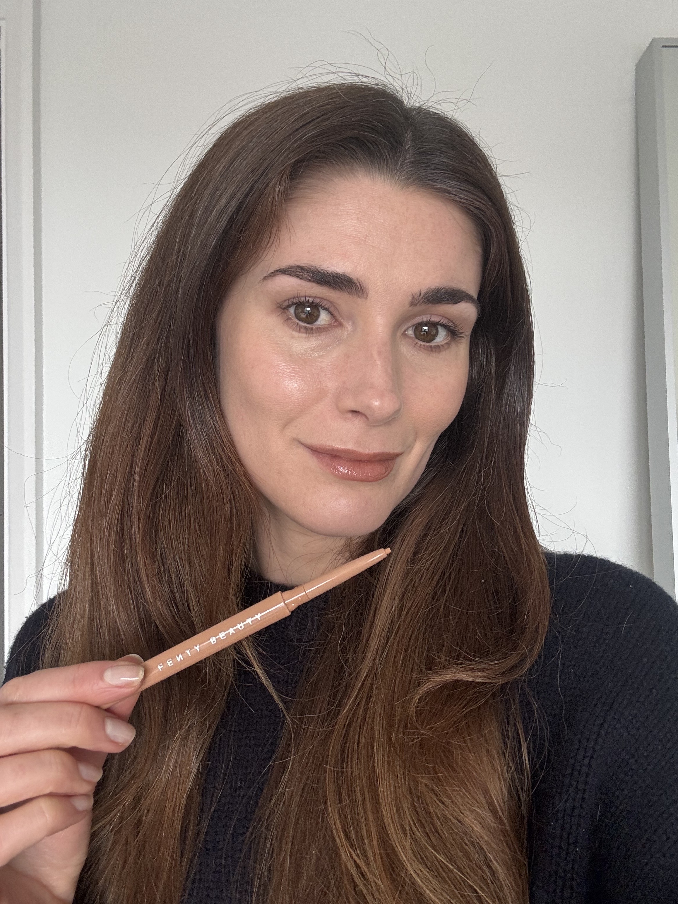 Eleanor using the Fenty Beauty eyeliner pencil in naked beach
