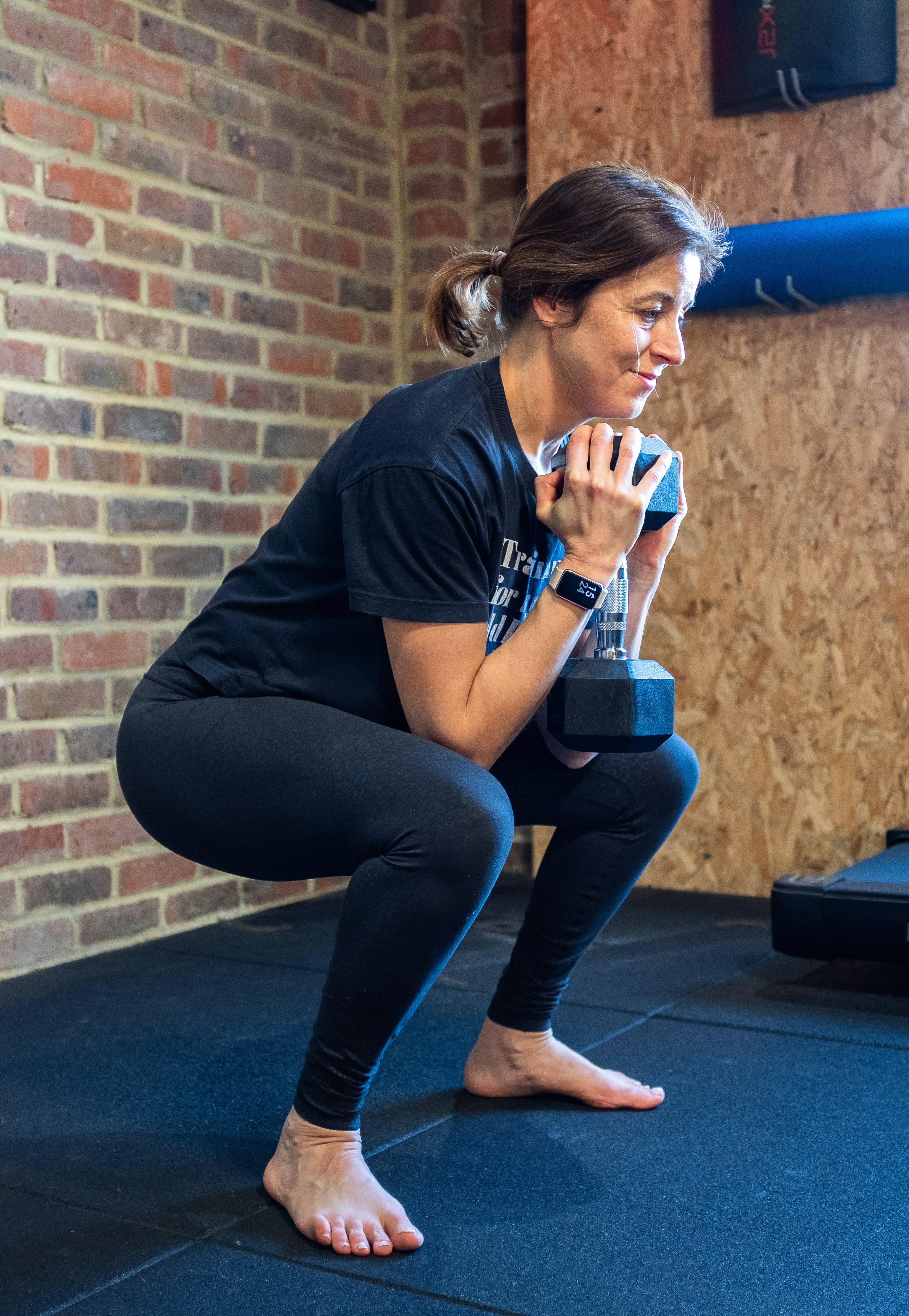 Elizabeth Davies doing squats with a dumbbell.