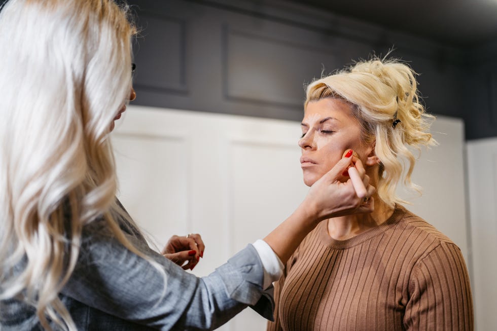 Makeup History Facts You Should Know But Don't  Mid-Adult Female Beautician Putting A Bronzer On A Mid-Adult Female Client While Doing Her Makeup At A Beauty Salon