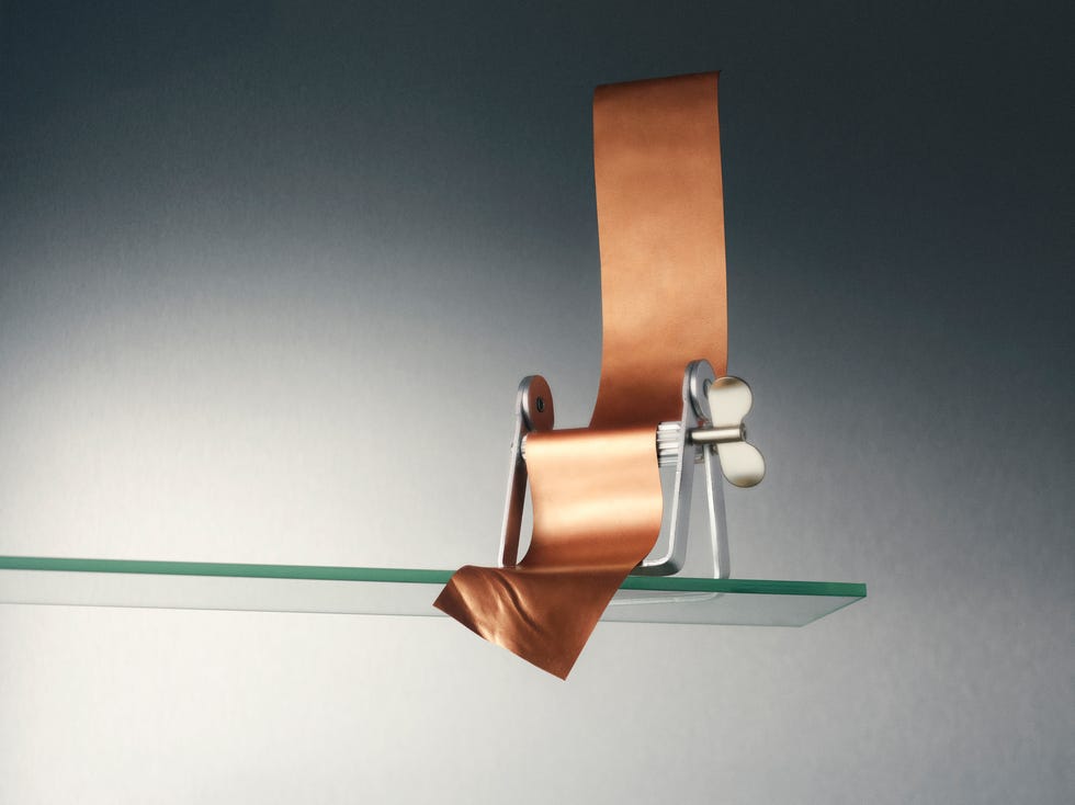 Copper strip being unwound from a metallic roller.