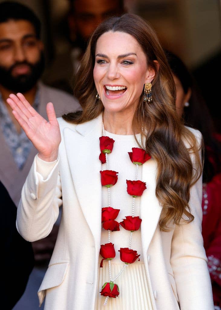 Kate Middleton waving while wearing a white dress