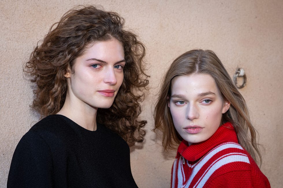 two individuals with obscured faces posing together