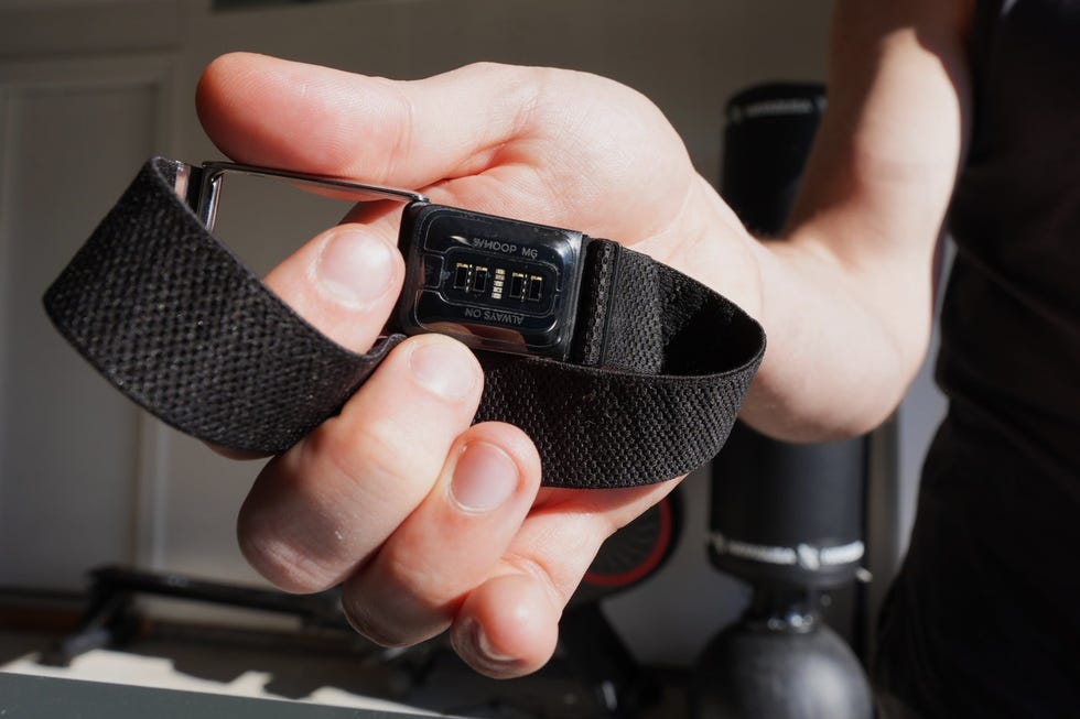 fitness tracker held in a hand displaying monitoring features