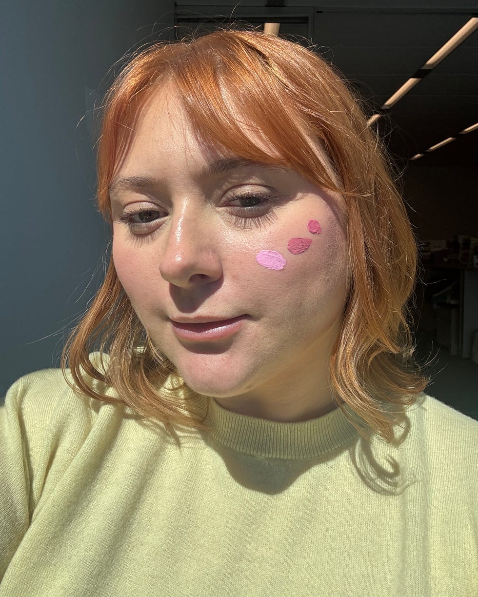 Person with partially blurred face, wearing a yellow sweater, in a well-lit indoor space.