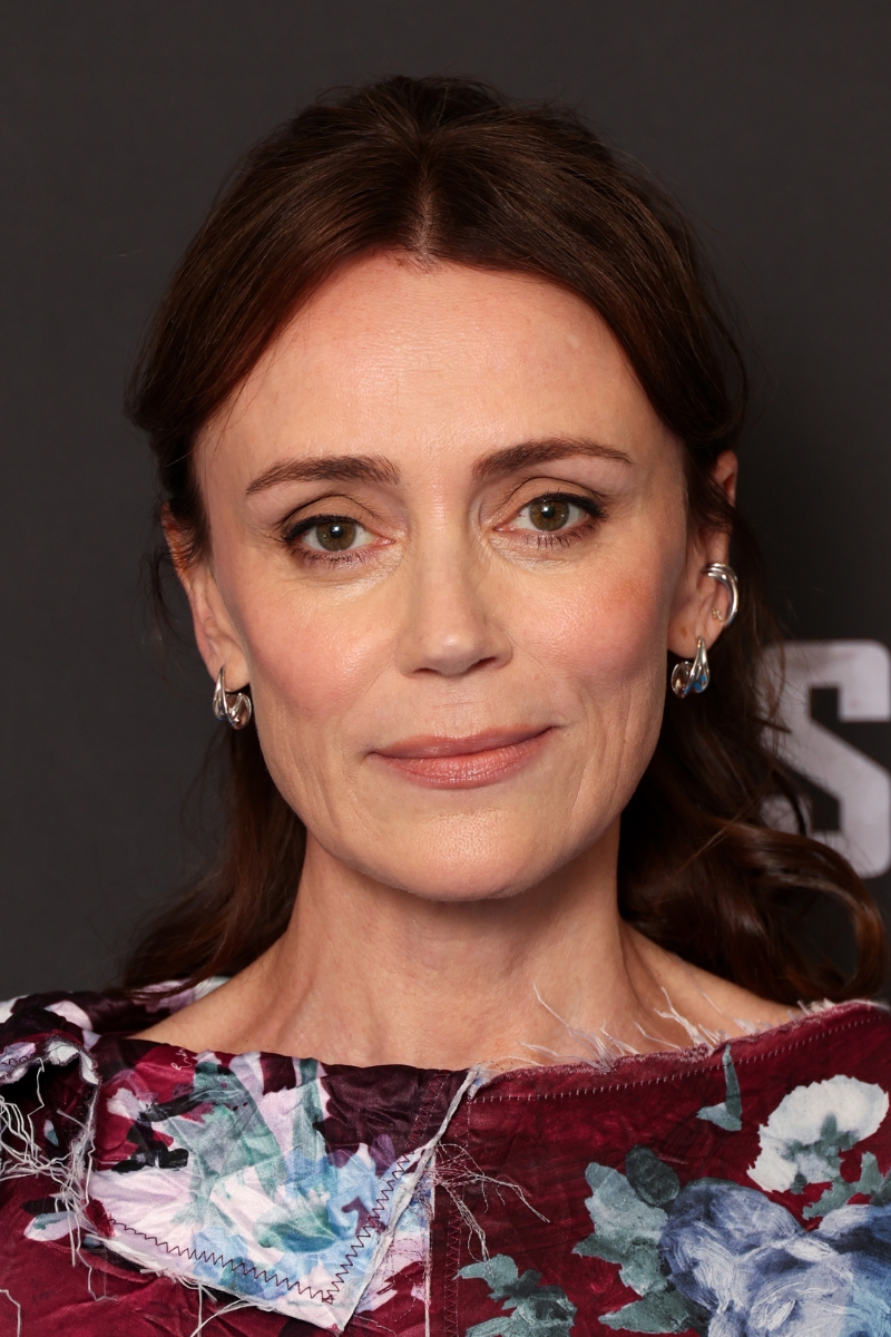 Keeley Hawes is pictured with warm, taupe-brown eyeshadow and wearing a floral burgundy and blue dress during the photocall for "The Assassin" at The Soho Hotel on July 03, 2025 in London, England.