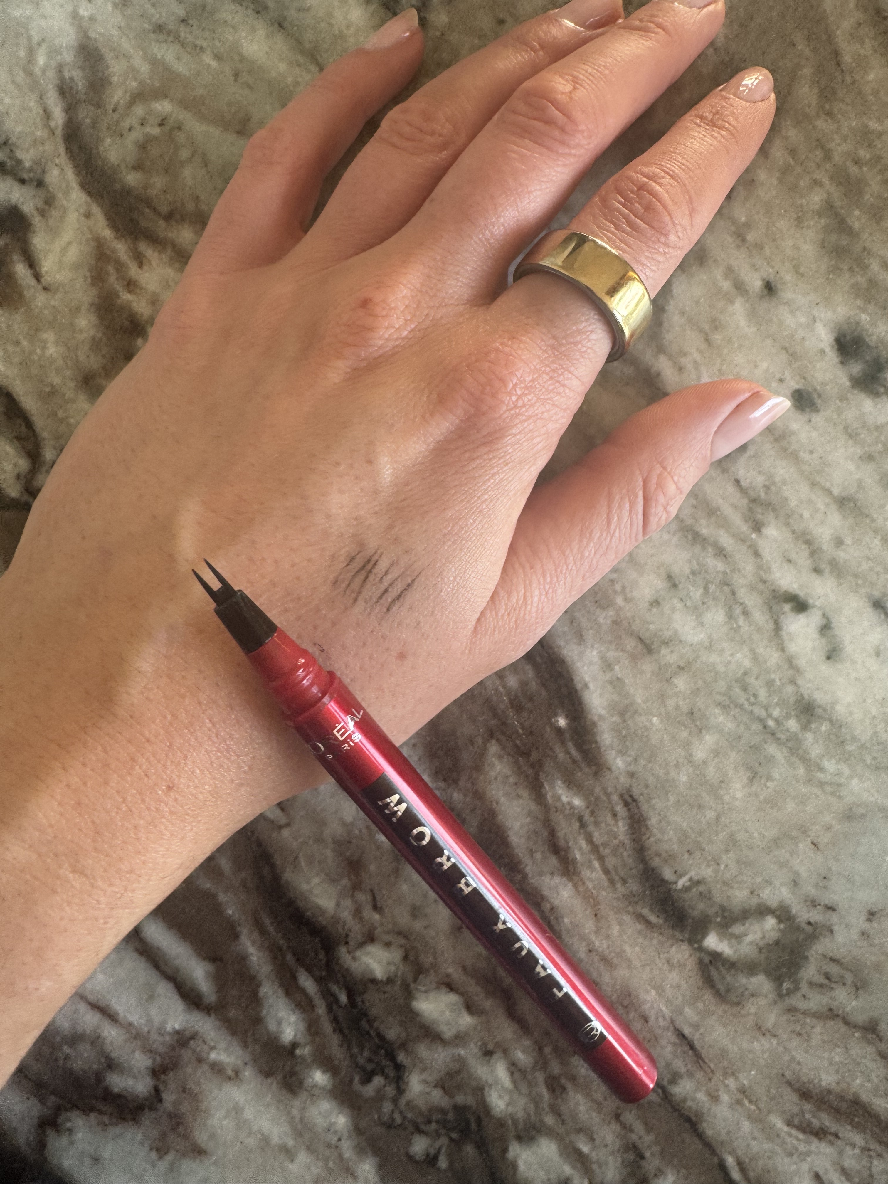 Beauty editor Eleanor swatching the L'Oreal Paris Faux Brow brow pen on her hand