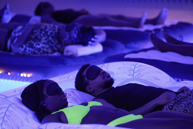 Yele Ajayi, left, and Cameron Dandridge lie on a raft in a pool during a sound healing session with wellness practitioner Cherish Hicks at the Ritz-Carlton spa, Feb. 11, 2026, in Chicago. (John J. Kim/Chicago Tribune)