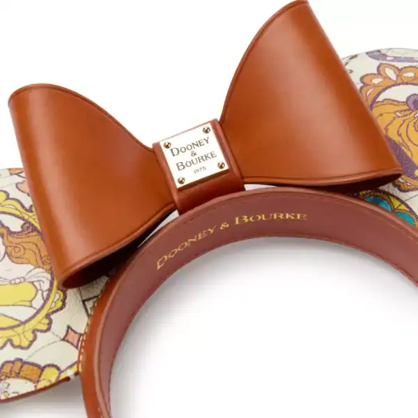 Chic Disney ears feature a paisley print, luxe brown leather bow with Dooney & Bourke logo, and a gold nameplate for fans.