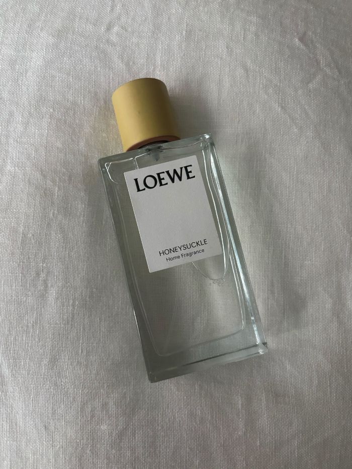 A Loewe room spray on a white linen background