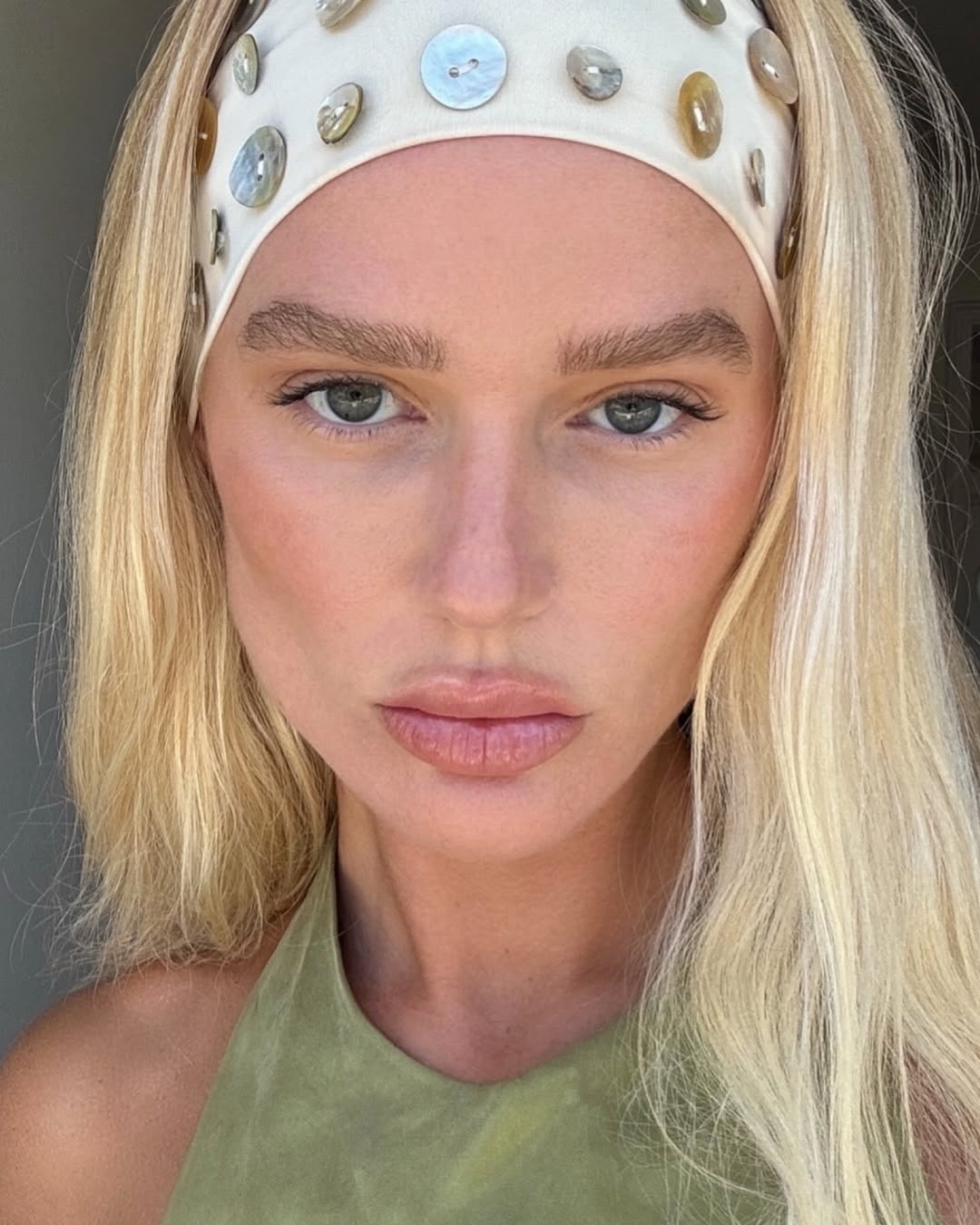 Megan Adelaide with bronzed makeup and a headband with abalone shell details