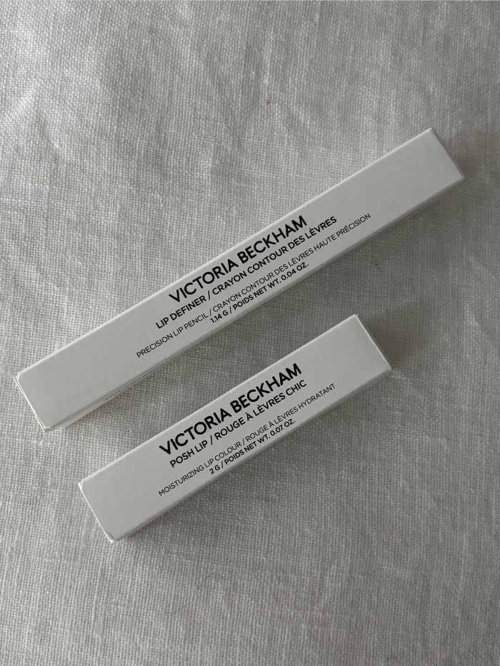 A Victoria Beckham Beauty lipstick and lip liner on a white linen background