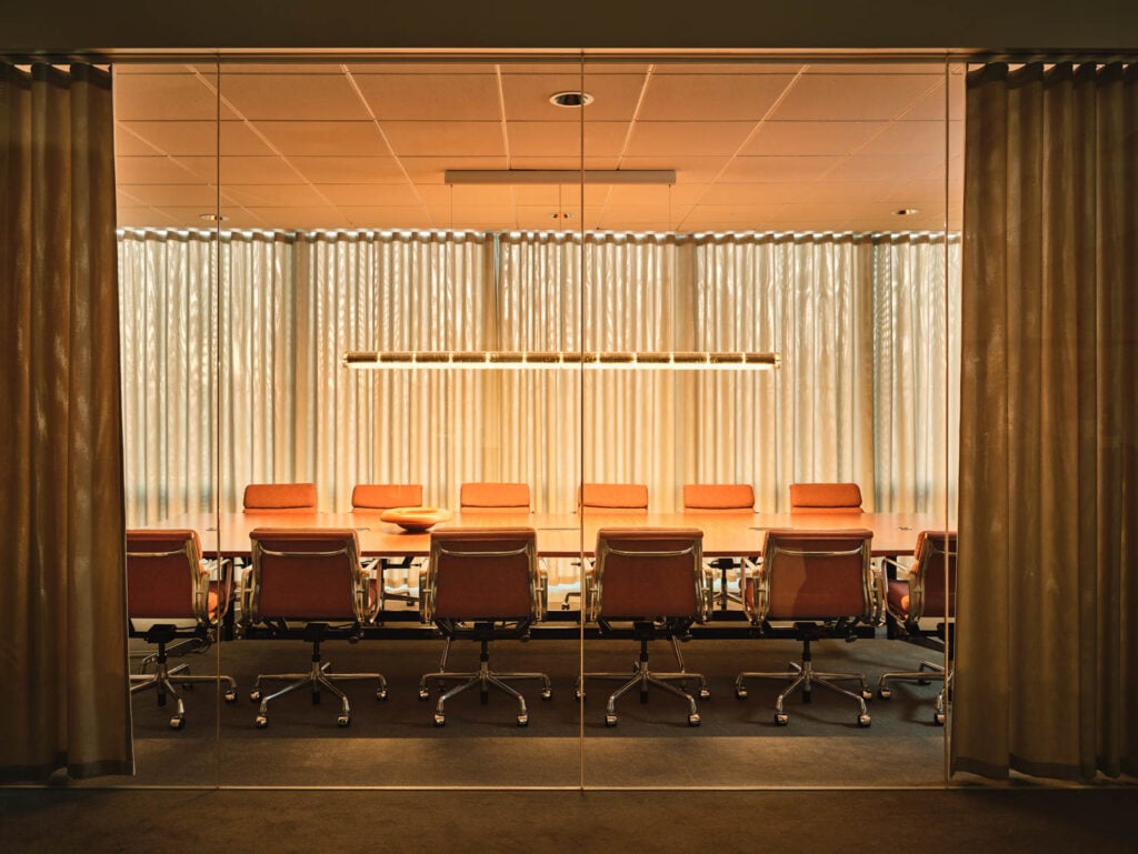 a conference table with orange chairs in the pattern beauty office