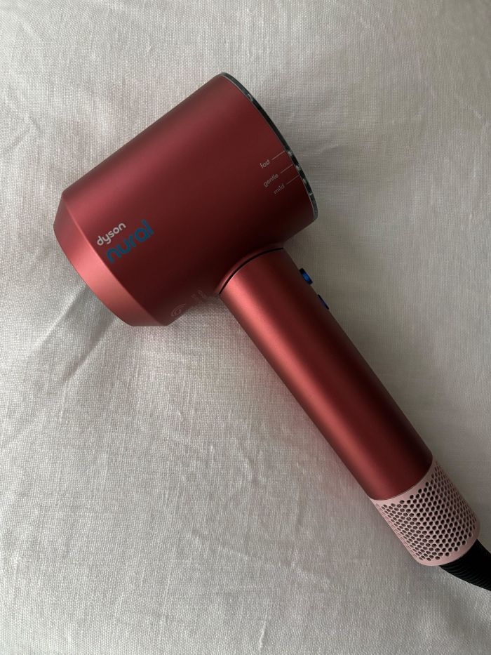 The Dyson Nural Hair Dryer on a white linen background
