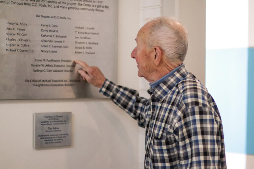 Funkhouser points out his name on a plaque in the Beede Swim and Fitness Center. Photo: Trace Salzbrenner/Concord Bridge