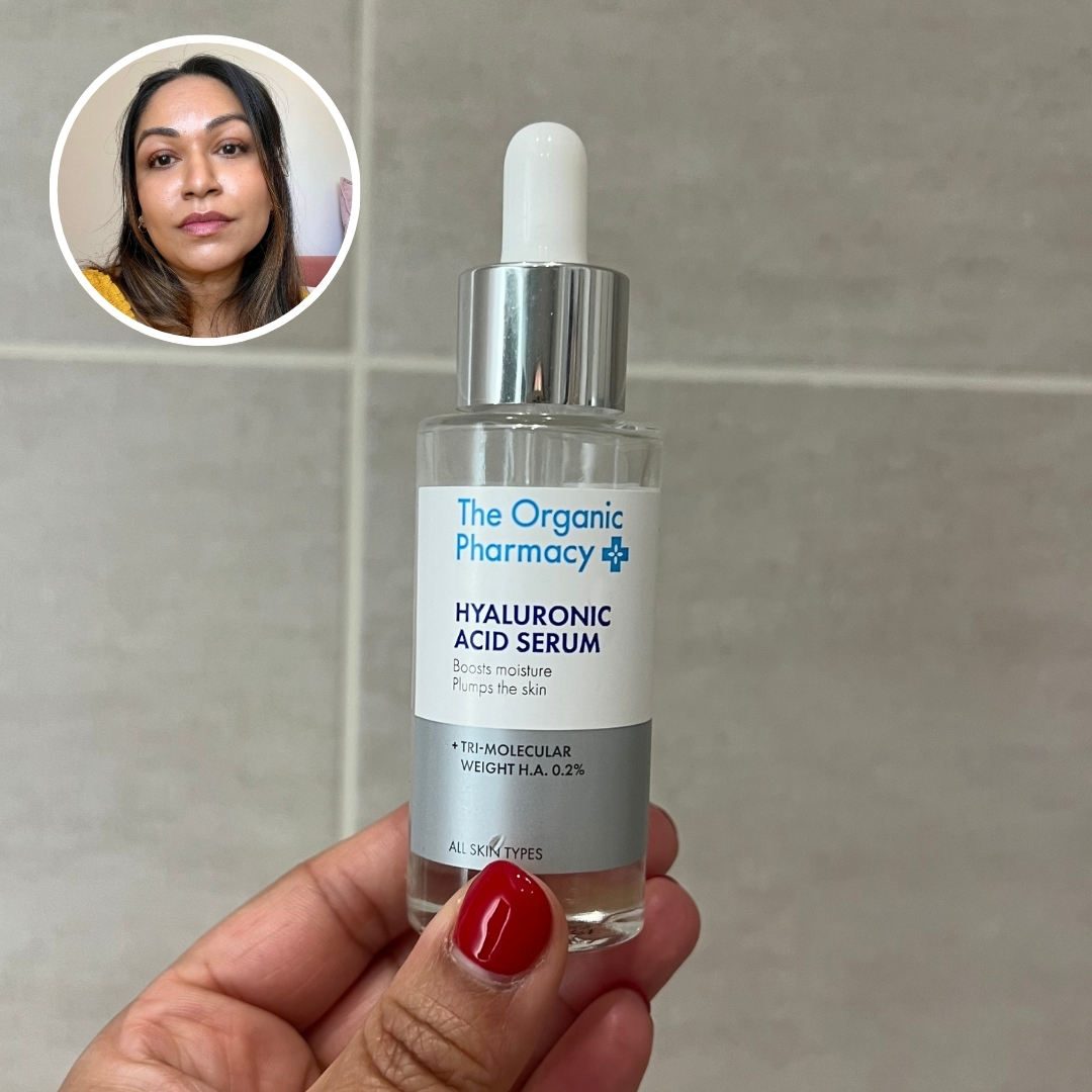 Hand holding an empty bottle of The Organic Pharmacy Hyaluronic Acid Serum, with circular photo of Aleesha Badkar in top left corner