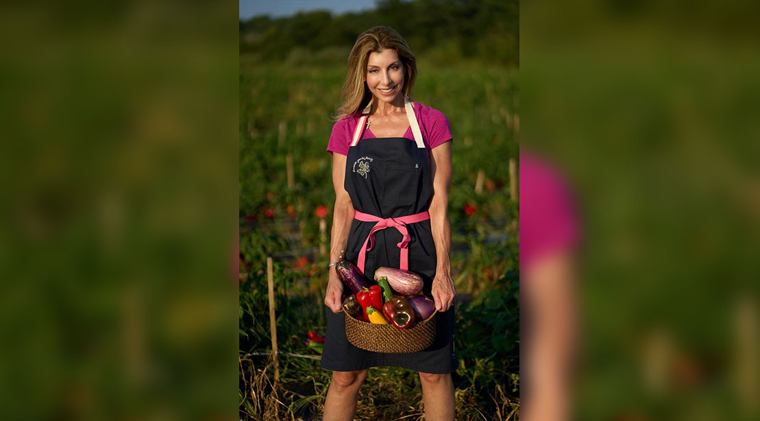 Shereen Pavlides in her garden holding a basket of vegetable