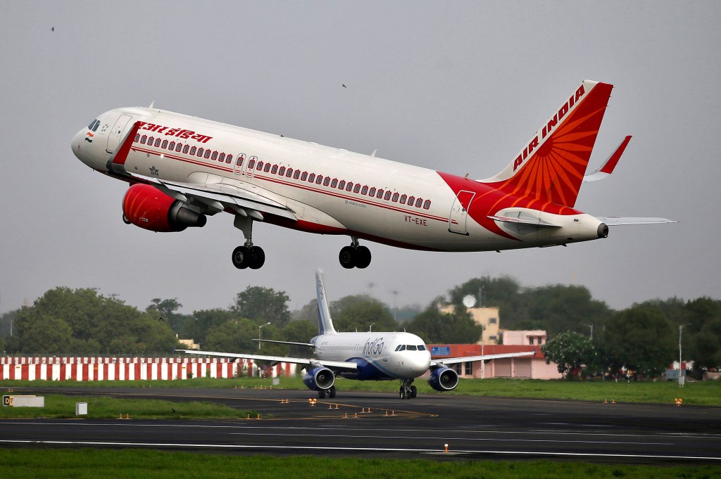 An Air India Airbus A320 aircraft takes off as an IndiGo Airlines aircraft waits for clearance at the Sardar Vallabhbhai Patel International Airport in Ahmedabad.