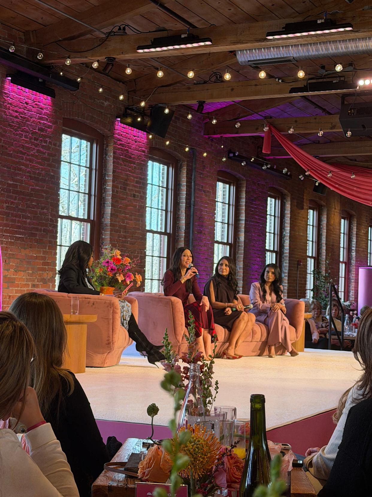 a panel discussion with multiple speakers seated on a stage
