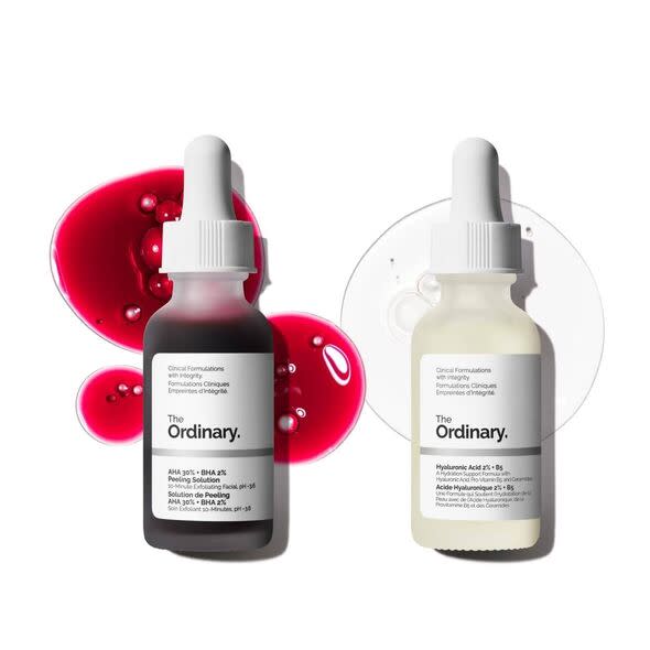 Two cosmetic serum bottles, one with a dark red liquid and the other with a light white liquid, both labeled