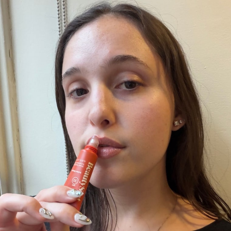 Woman applying lip serum to lips