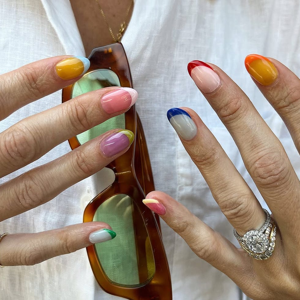 Colorful manicured nails holding sunglasses