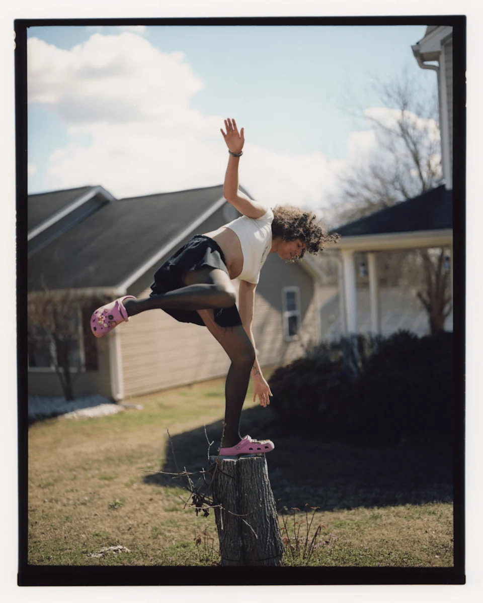 Quartz balances on a tree stump in a suburban yard.