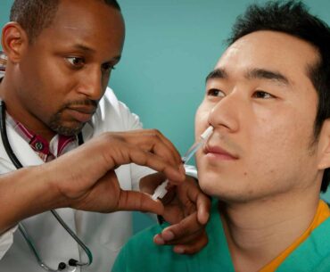 A healthcare practitioner administering a nasal spray vaccine. Credit: CDC