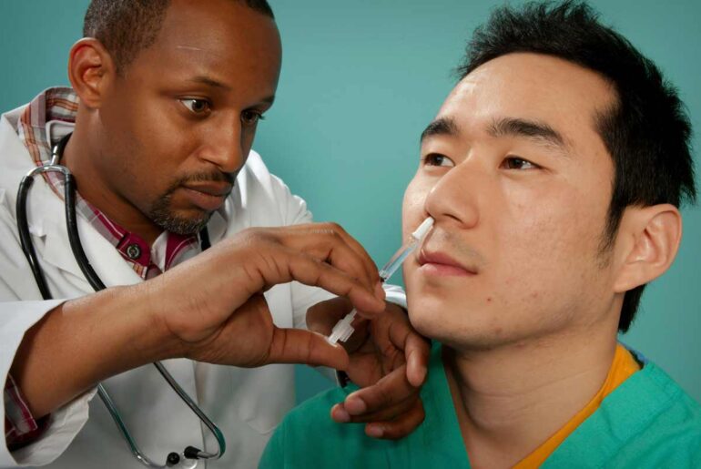 A healthcare practitioner administering a nasal spray vaccine. Credit: CDC
