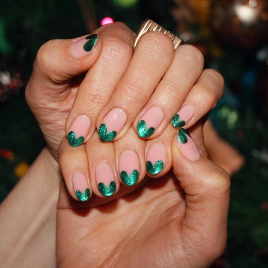 nail art featuring green heartshaped tips on a nude base