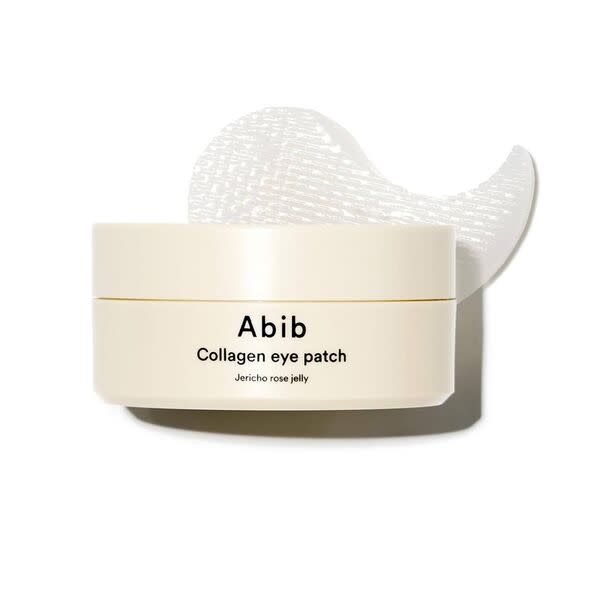 An image featuring a cylindrical container of Abi Collagen Eye Patch, resting on a plain background. The container is predominan