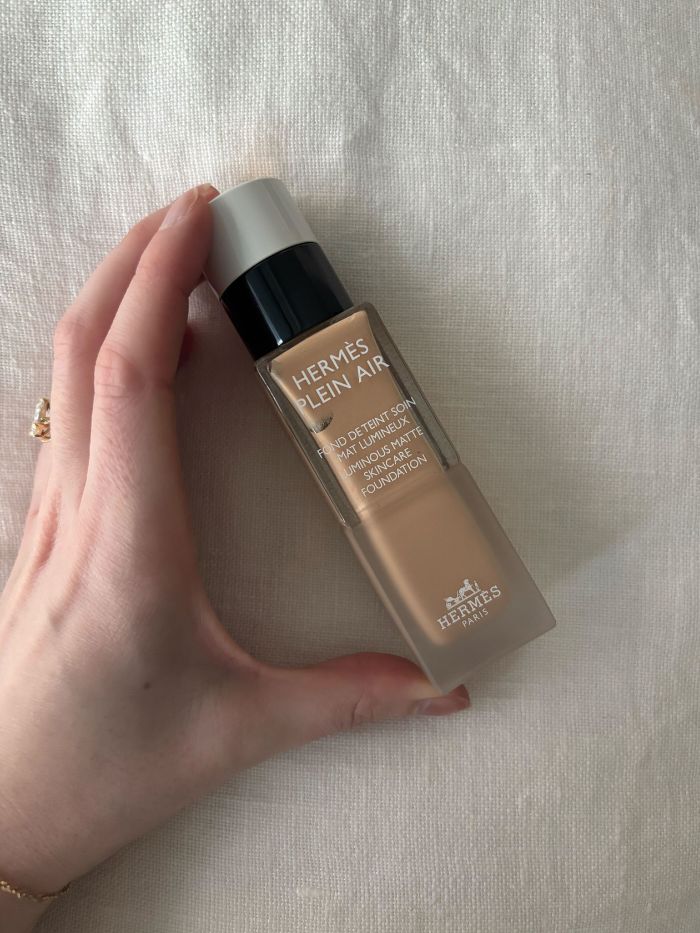Deputy beauty editor Grace Lindsay holding the Hermès Plein Air Luminous Matte Skincare Foundation