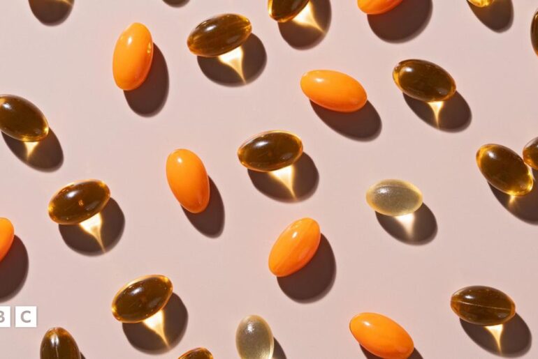 Various soft gel capsules on beige background