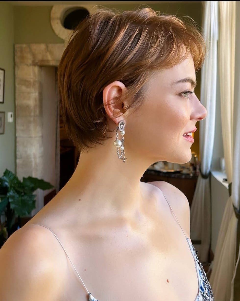 Portrait featuring a person with short brown hair and elegant earrings. Portrait featuring a person with short brown hair and elegant earrings.