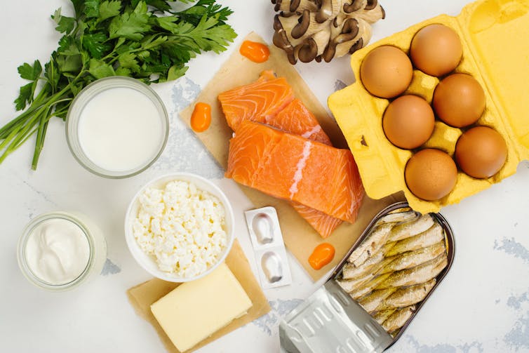 Array of foods on a marble surface, including salmon, eggs, mushrooms, cottage cheese and milk