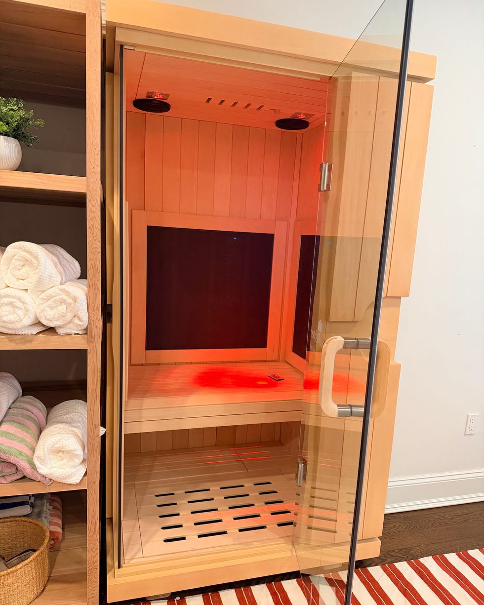 indoor sauna with glass door and red lighting