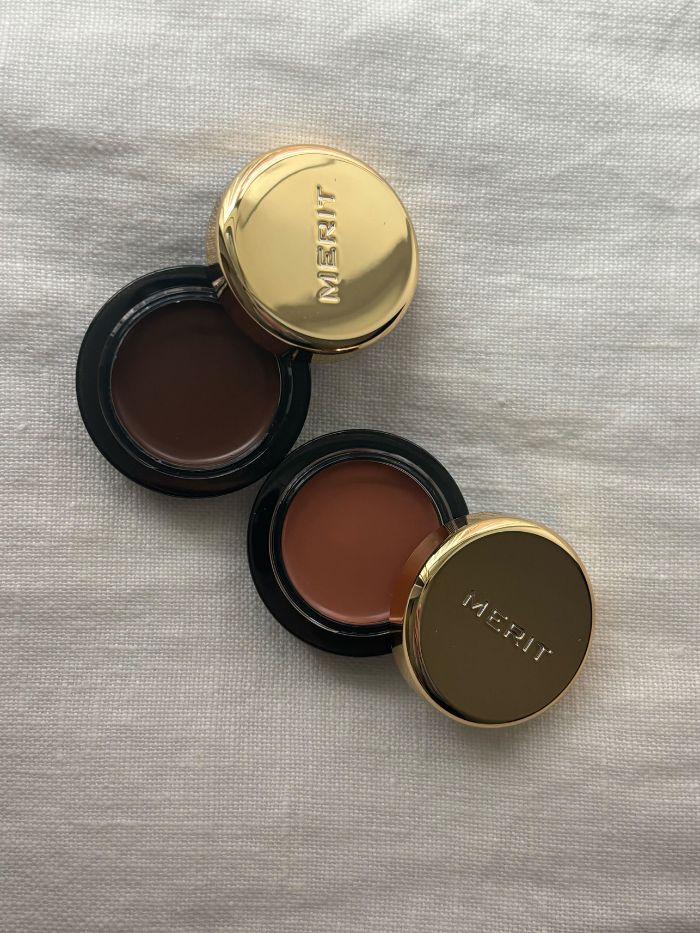 Two brown Merit eyeshadows on a white background