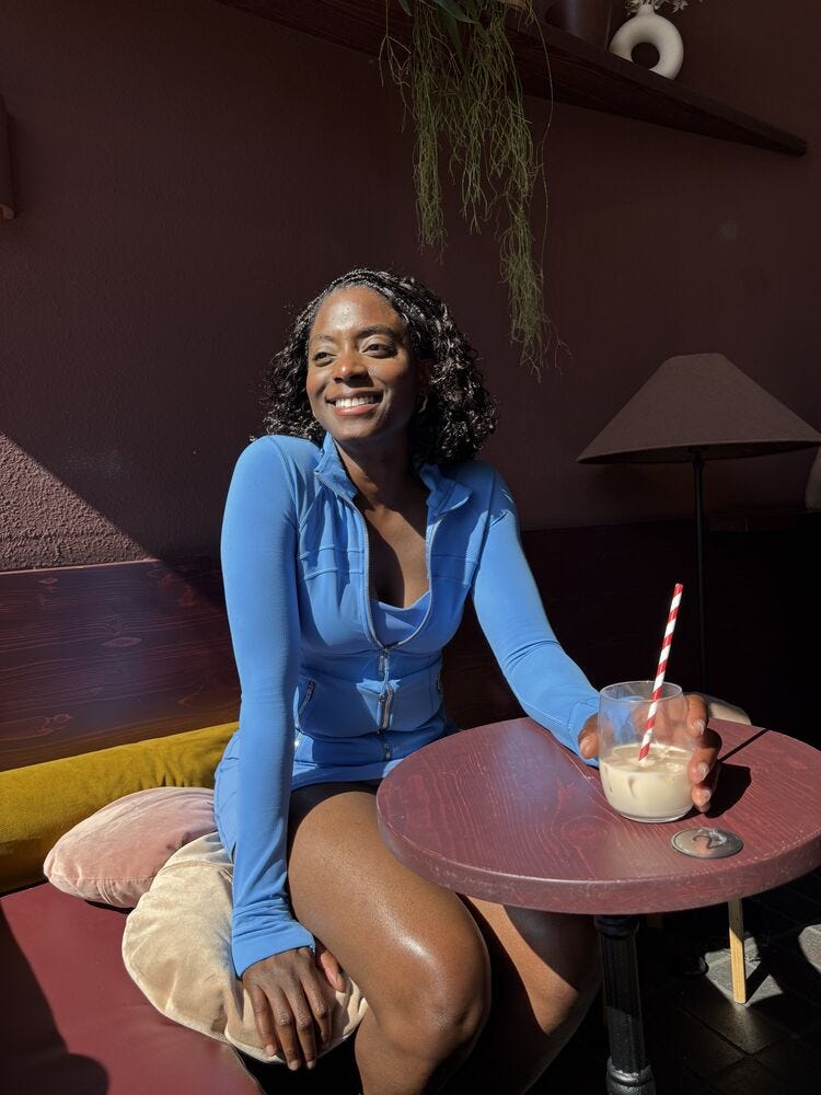 person sitting at a table in a cafe holding a drink
