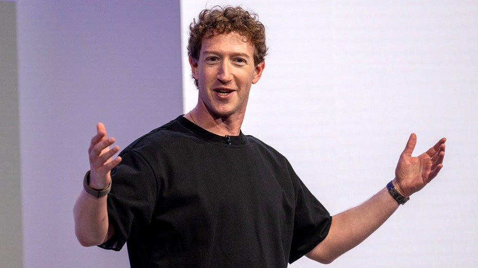 A technology executive stands on stage presenting new hardware during a company event.