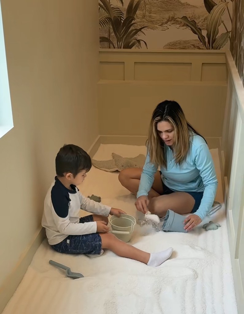 A mother and child playing in a small room filled with salt.