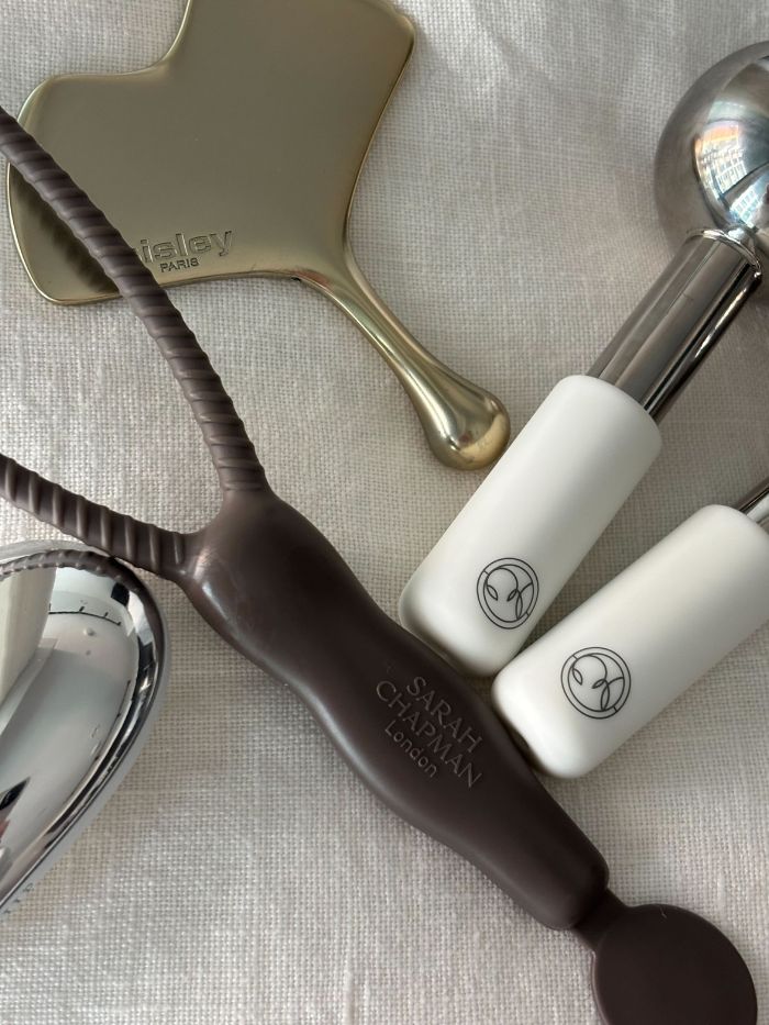 Some of the best facial massagers on a white linen background