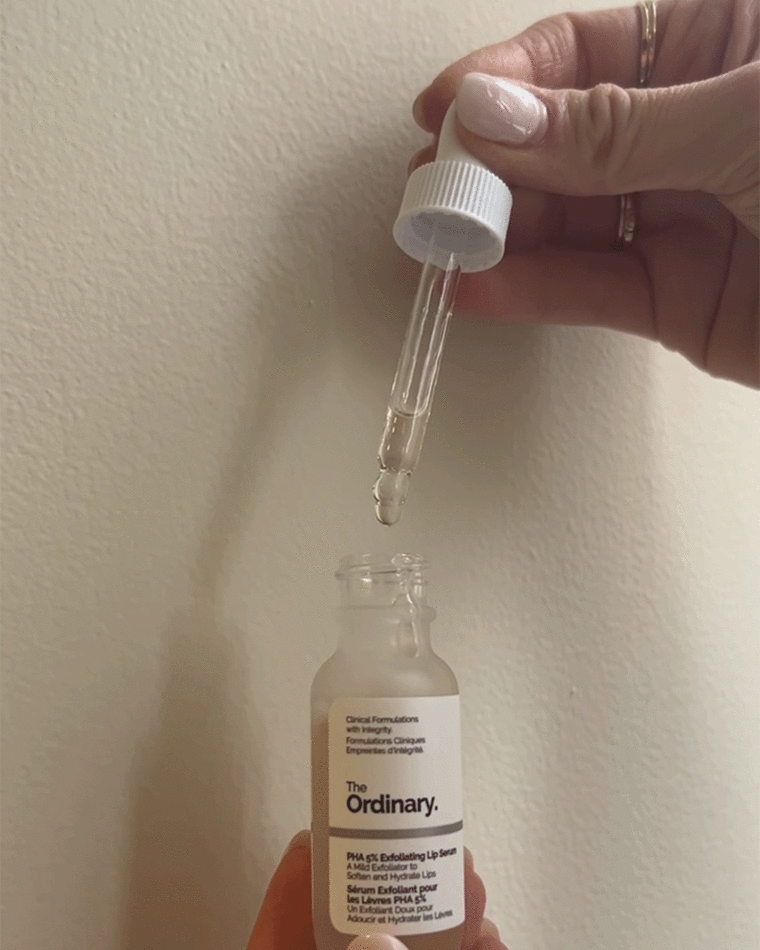 Woman squeezing serum using a dropper
