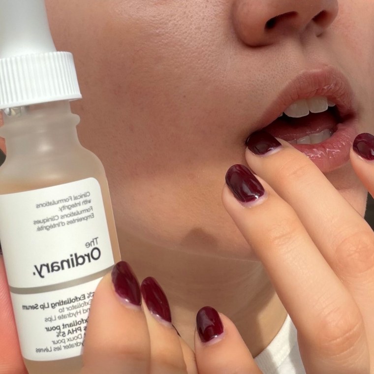 Woman applying lip serum to lips