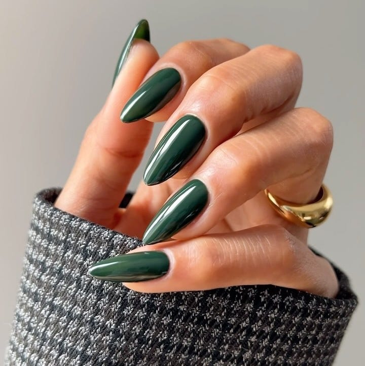 green long nails with a knitted gray sweater in the background