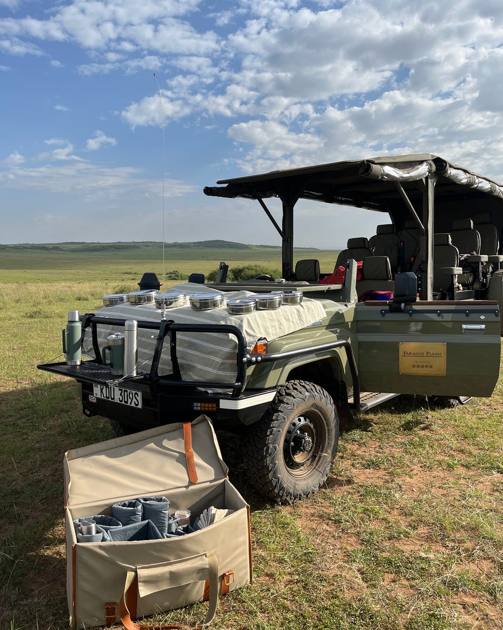 safari vehicle parked in a grassy landscape with a clear sky paradise plains kenya