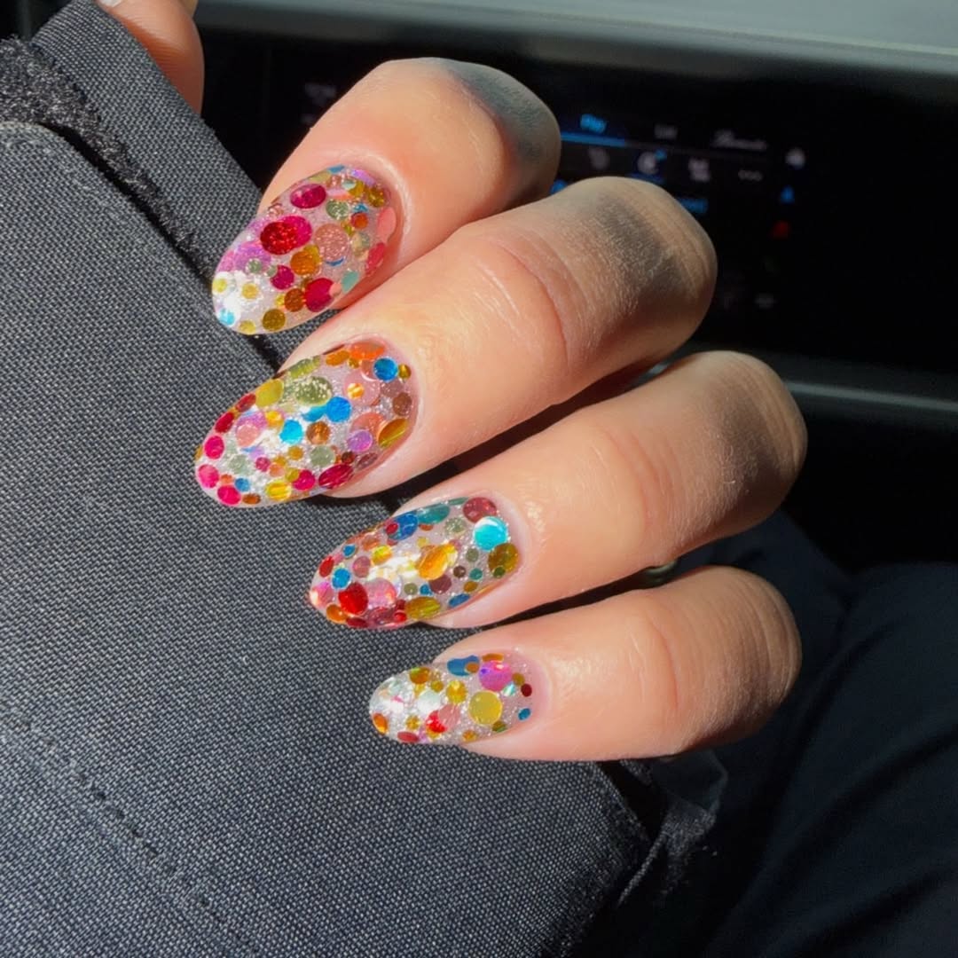 colorful glittery nail art featuring multiple shades of dots