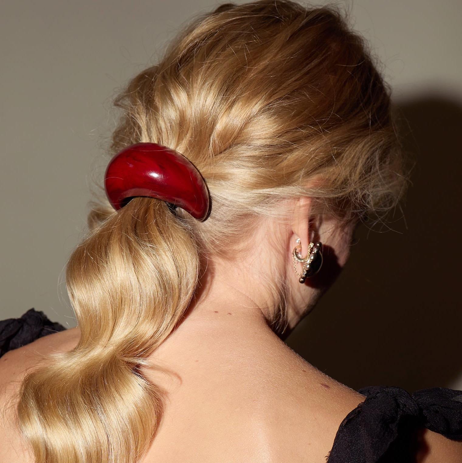 closeup of a womans hair styled with a red hair clip