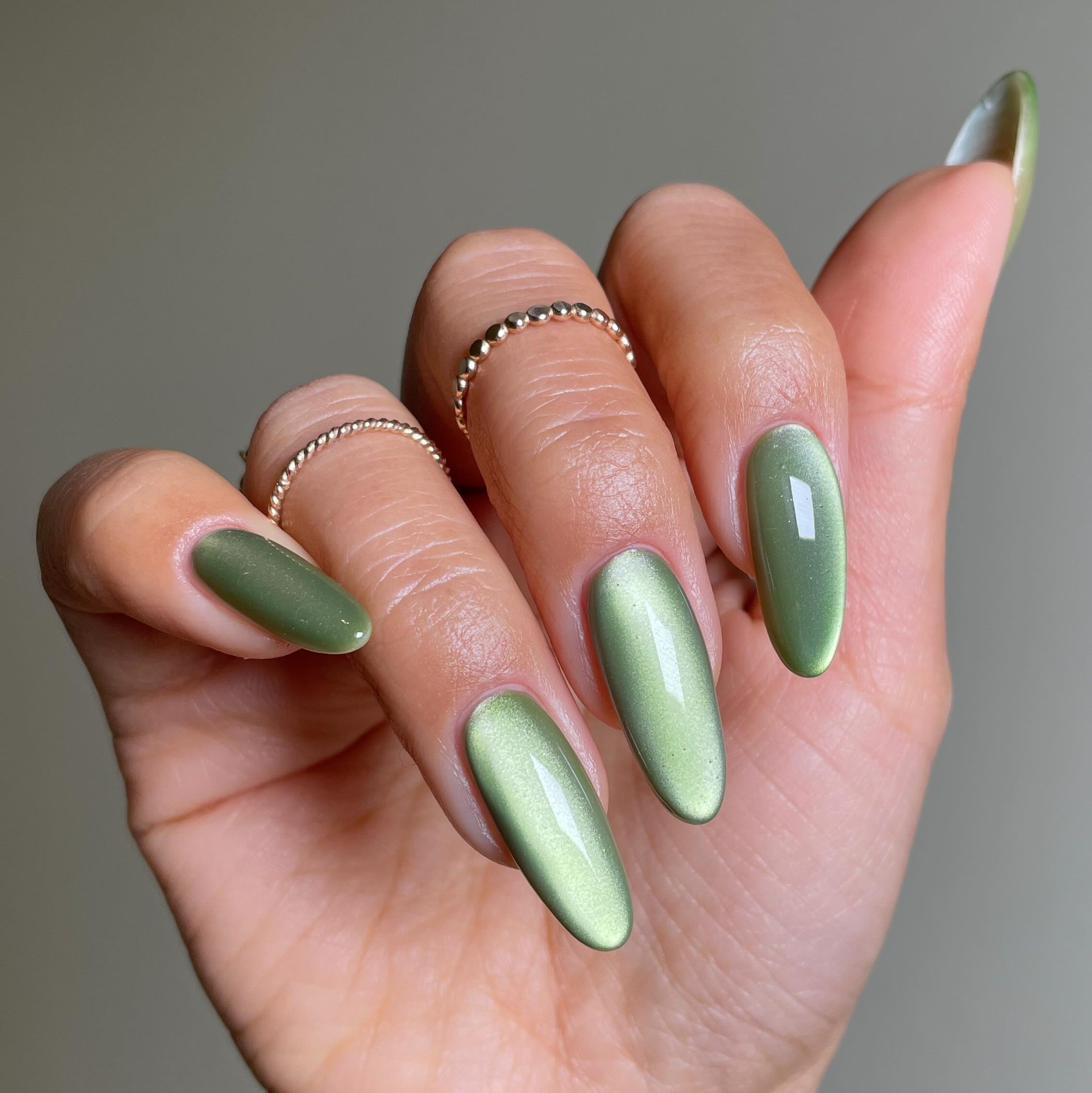 green metallic nail design with rings