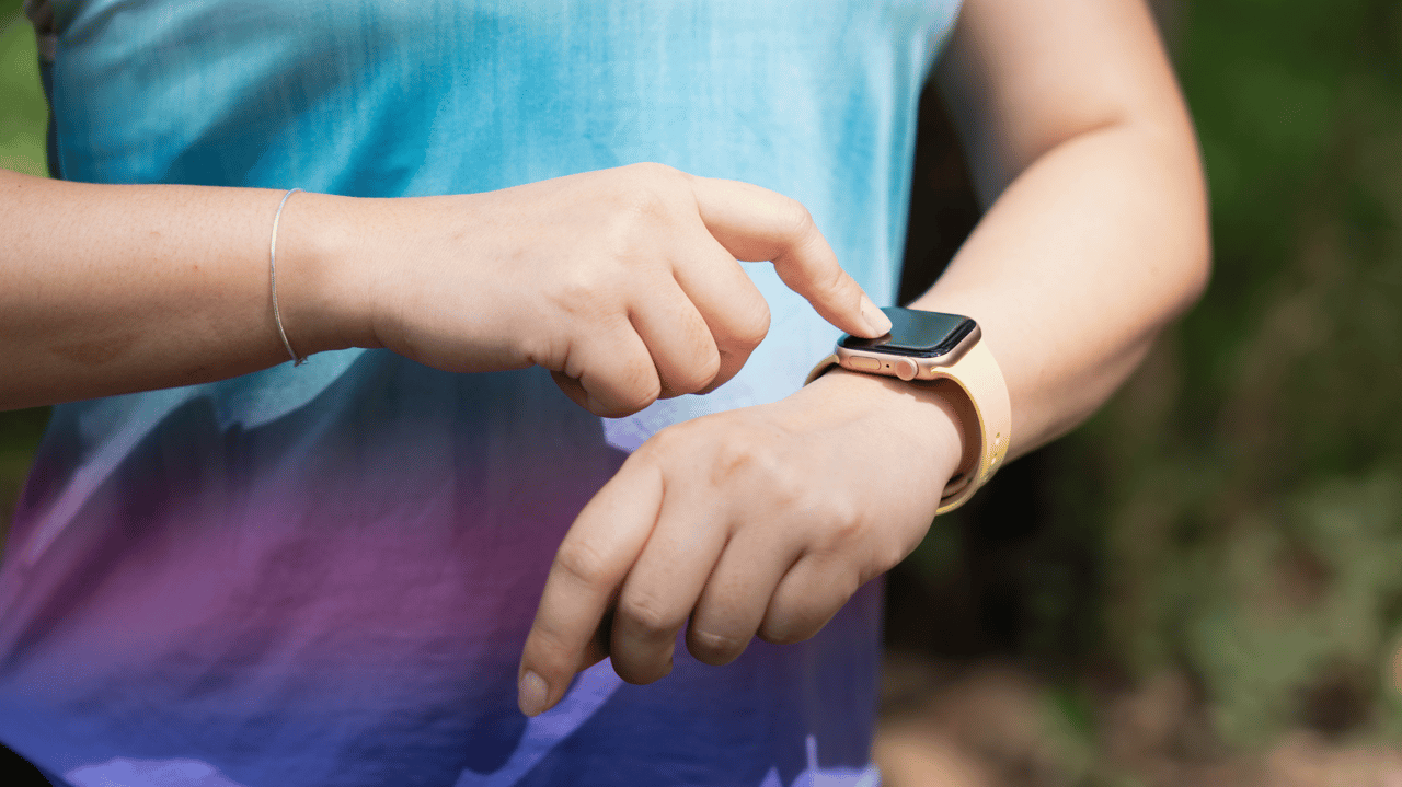 Woman checks fitness watch Woman checks fitness watch