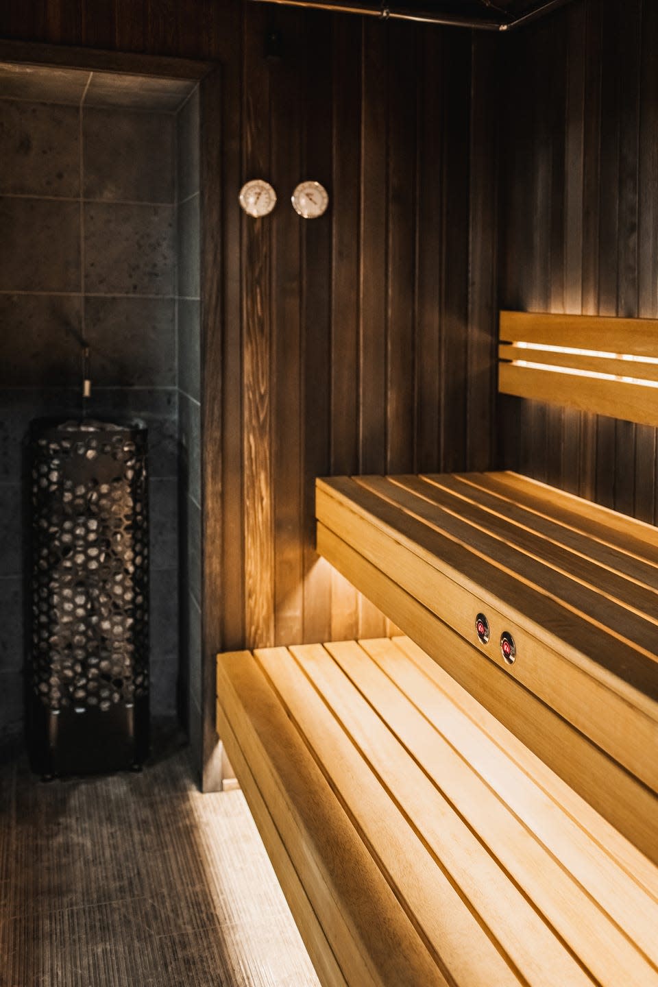 Wooden interior of traditional finnish sauna. Stone heater and wooden shelves.
